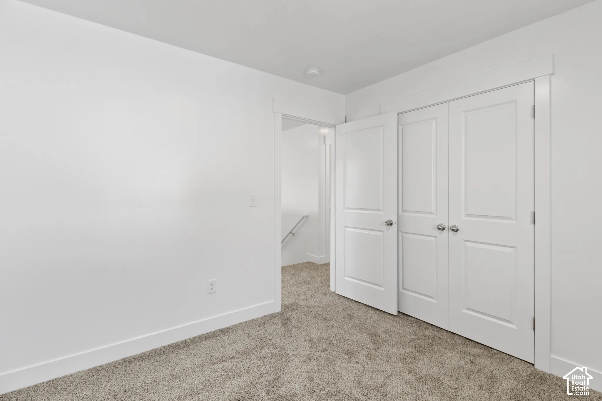 Neutral-toned carpeting, white walls, and white trim