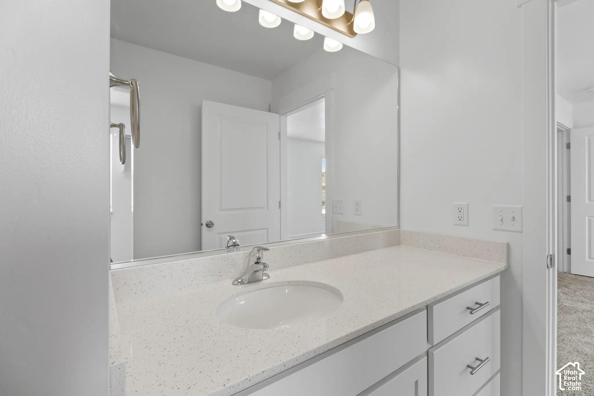 Vanity with an integrated sink, polished chrome faucet, and white countertop