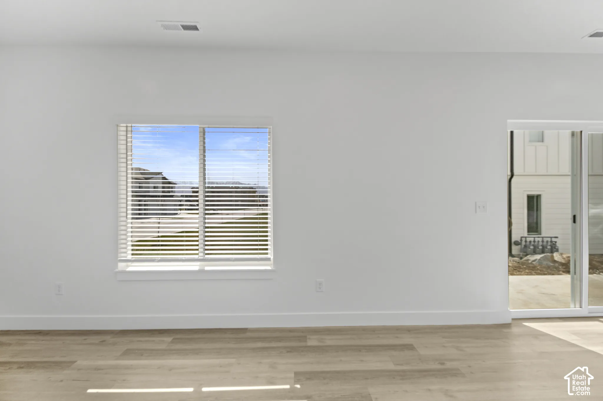 Light wood-finish flooring with white baseboards