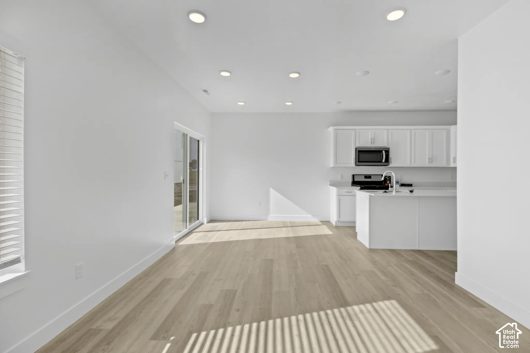 Open-concept living area featuring wood-finish flooring and recessed lighting