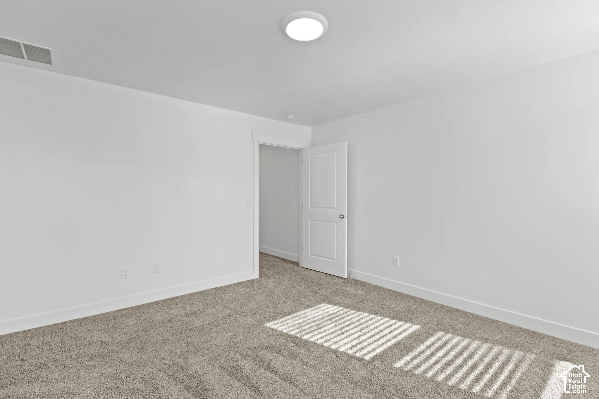 Neutral color palette with carpeted flooring and a modern flush-mount ceiling light