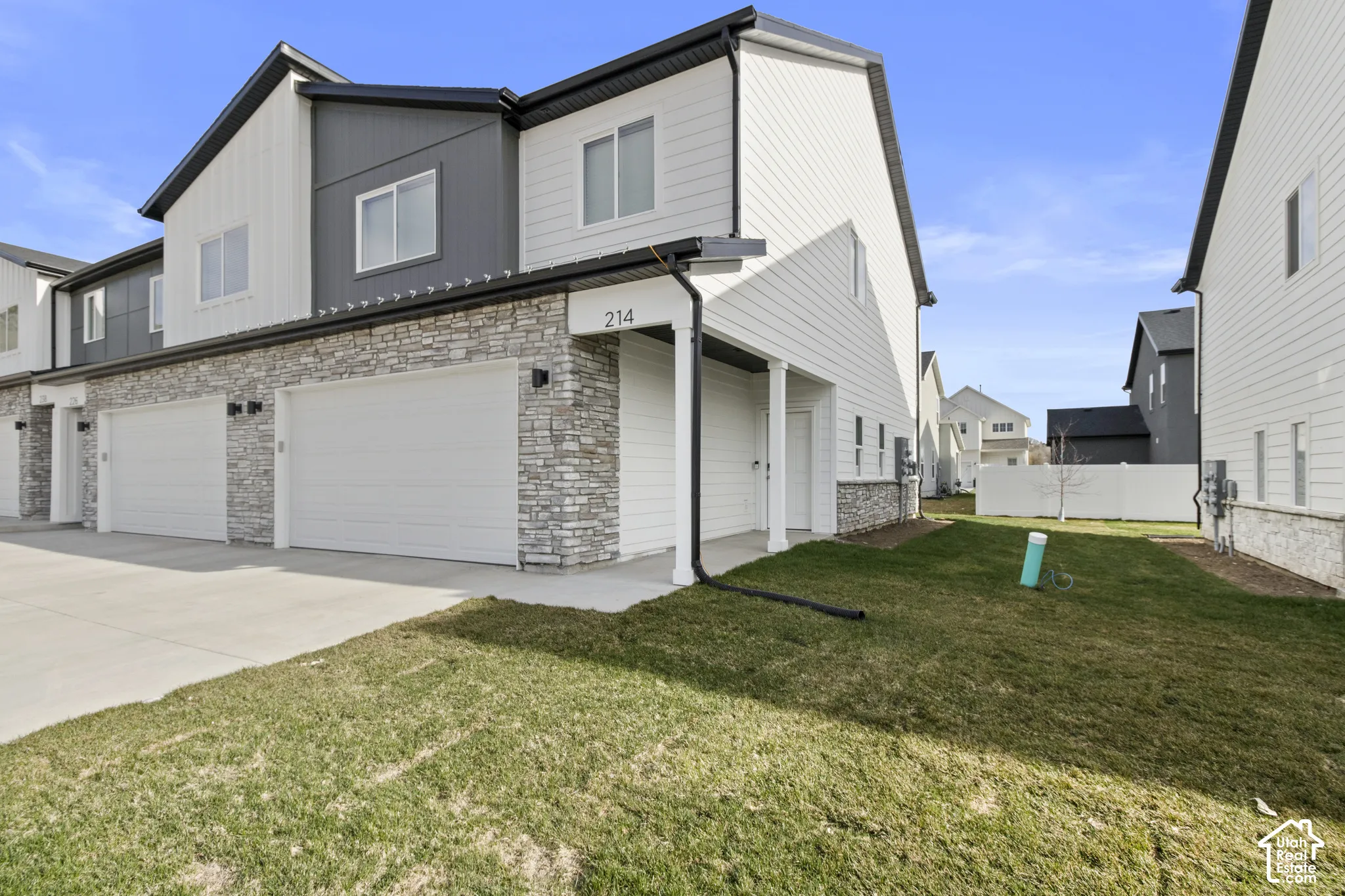 Contemporary exterior with horizontal and vertical siding, stone accents, and a dual garage