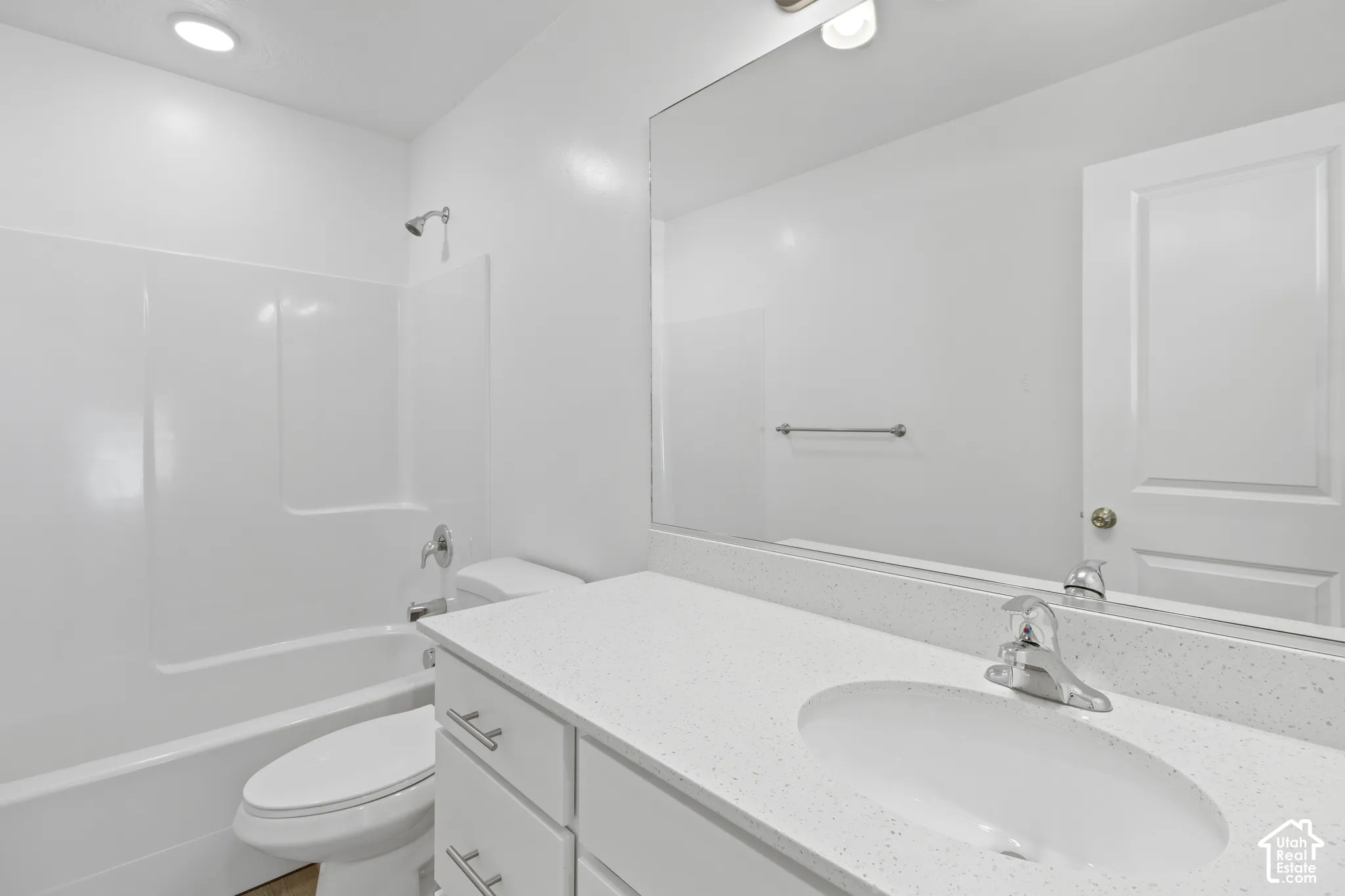 White vanity with integrated sink, chrome faucet, and white countertop