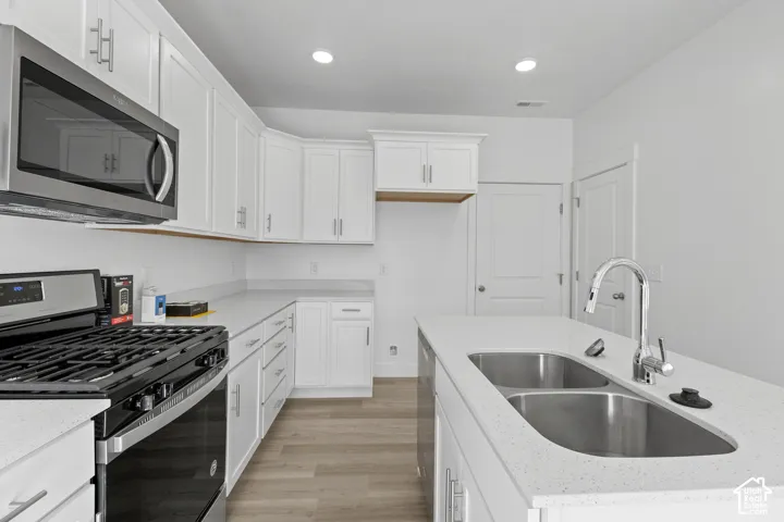 Modern kitchen featuring white cabinetry and light-toned countertops