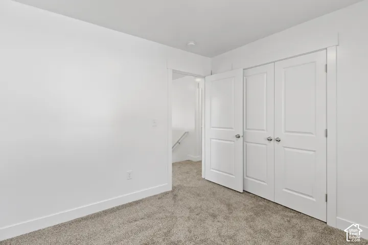 Neutral-toned carpeting, white walls, and white trim