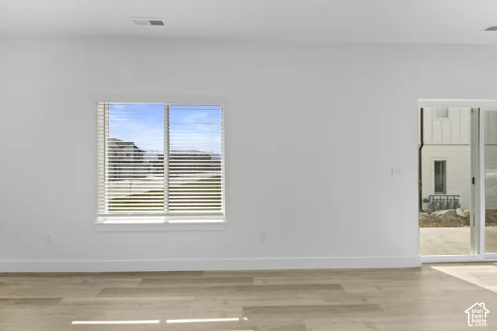 Light wood-finish flooring with white baseboards