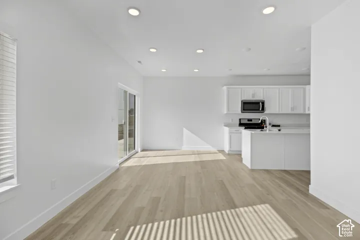 Open-concept living area featuring wood-finish flooring and recessed lighting