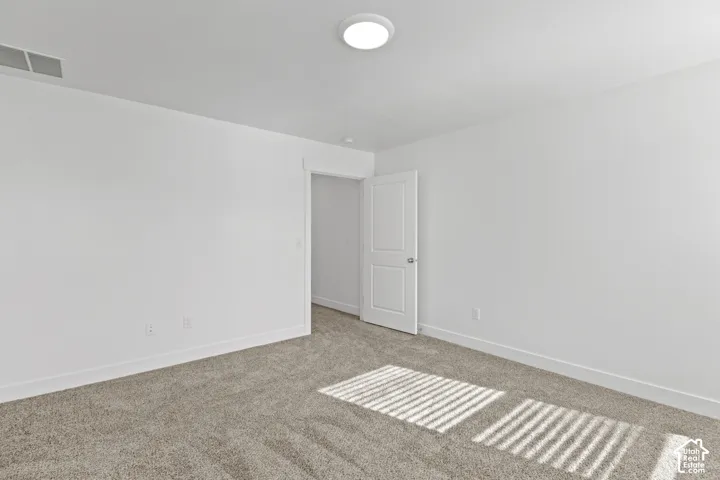 Neutral color palette with carpeted flooring and a modern flush-mount ceiling light