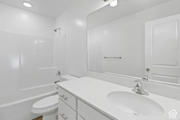 White vanity with integrated sink, chrome faucet, and white countertop