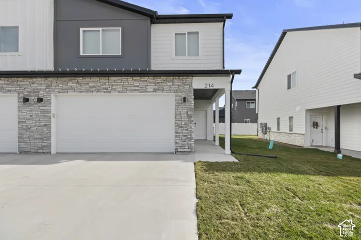 Contemporary exterior with mixed material siding, stone veneer accents, and a two-car garage