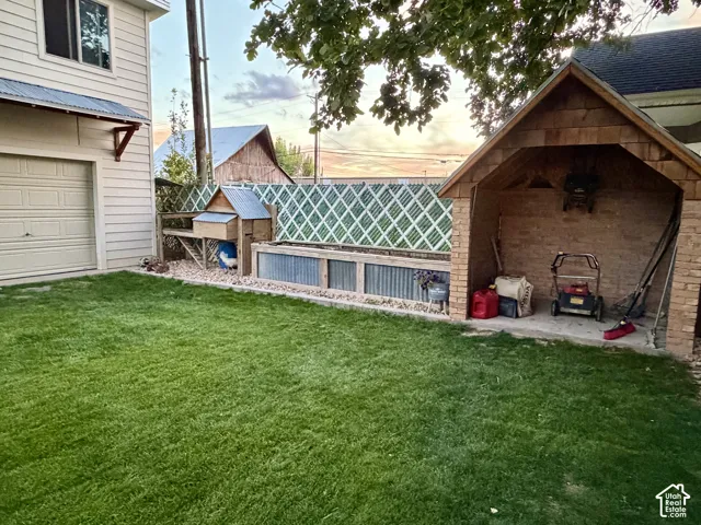 Expansive green lawn, brick-finish outdoor storage structure, corrugated metal planter boxes, and a built-in chicken coop