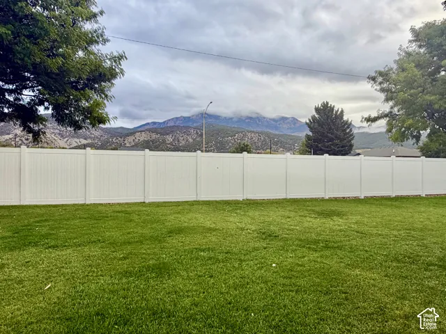 Expansive lawn area with a full-height white privacy fence