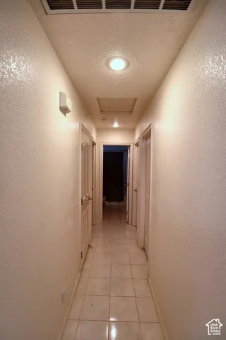 Recessed ceiling lighting, flush-mounted ceiling light, square tile flooring, multiple interior doors, and wall-mounted light fixture