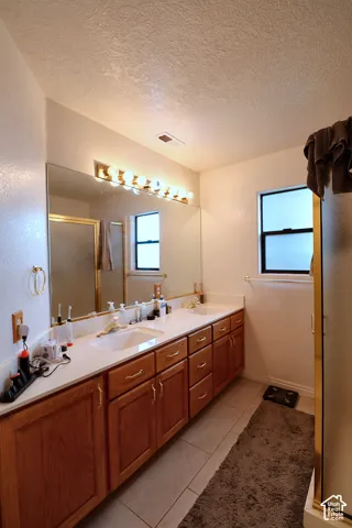 Dual vanity with integrated sinks, wood cabinetry, and a full-width mirror