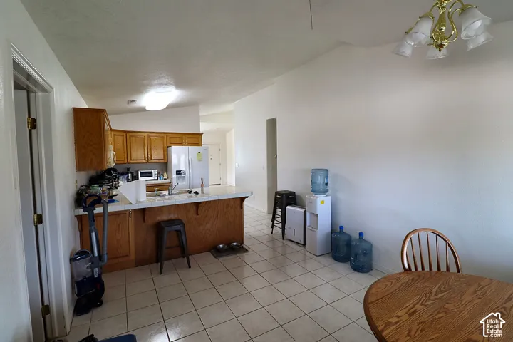 Kitchen featuring wood cabinetry, white appliances, and a tiled countertop