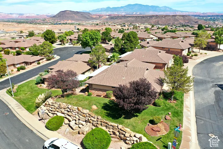 Residential neighborhood with mature landscaping, paved roads, and distant mountain scenery