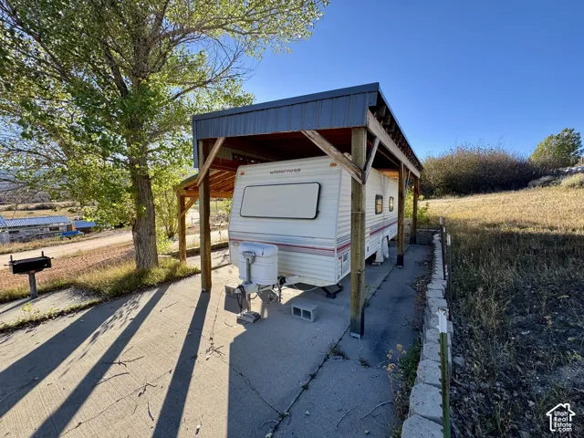 Covered parking structure with metal roofing and wood supports on lot 161