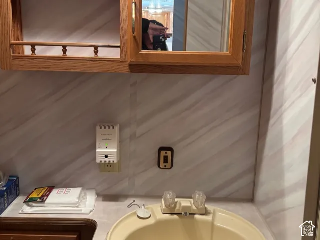 Laminate countertop with an integrated sink, dual-handle faucet, and wood-finish cabinetry