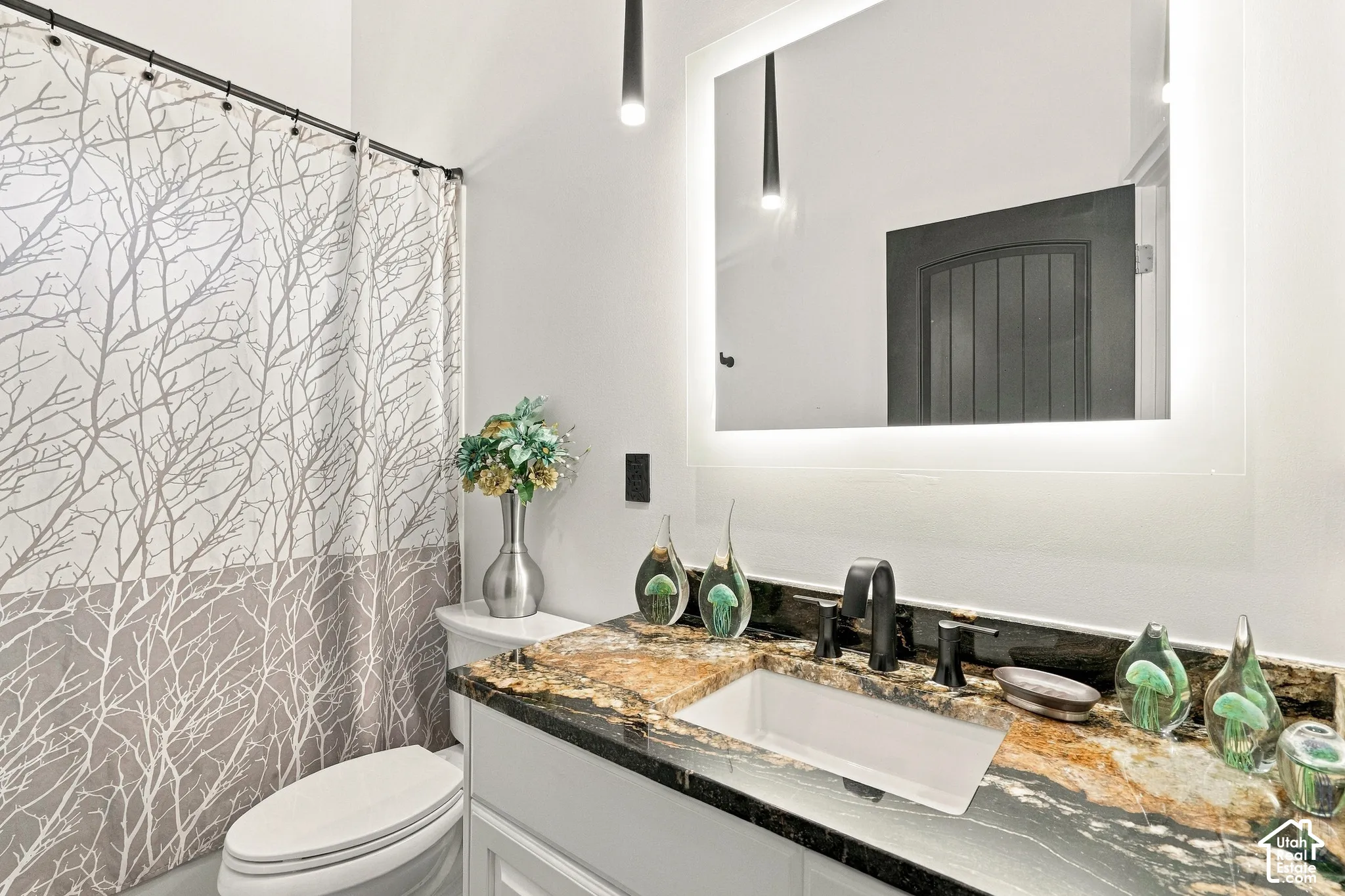 Spa-inspired bathroom featuring a floating vanity with a natural stone countertop, rectangular vessel sink, and matte black fixtures