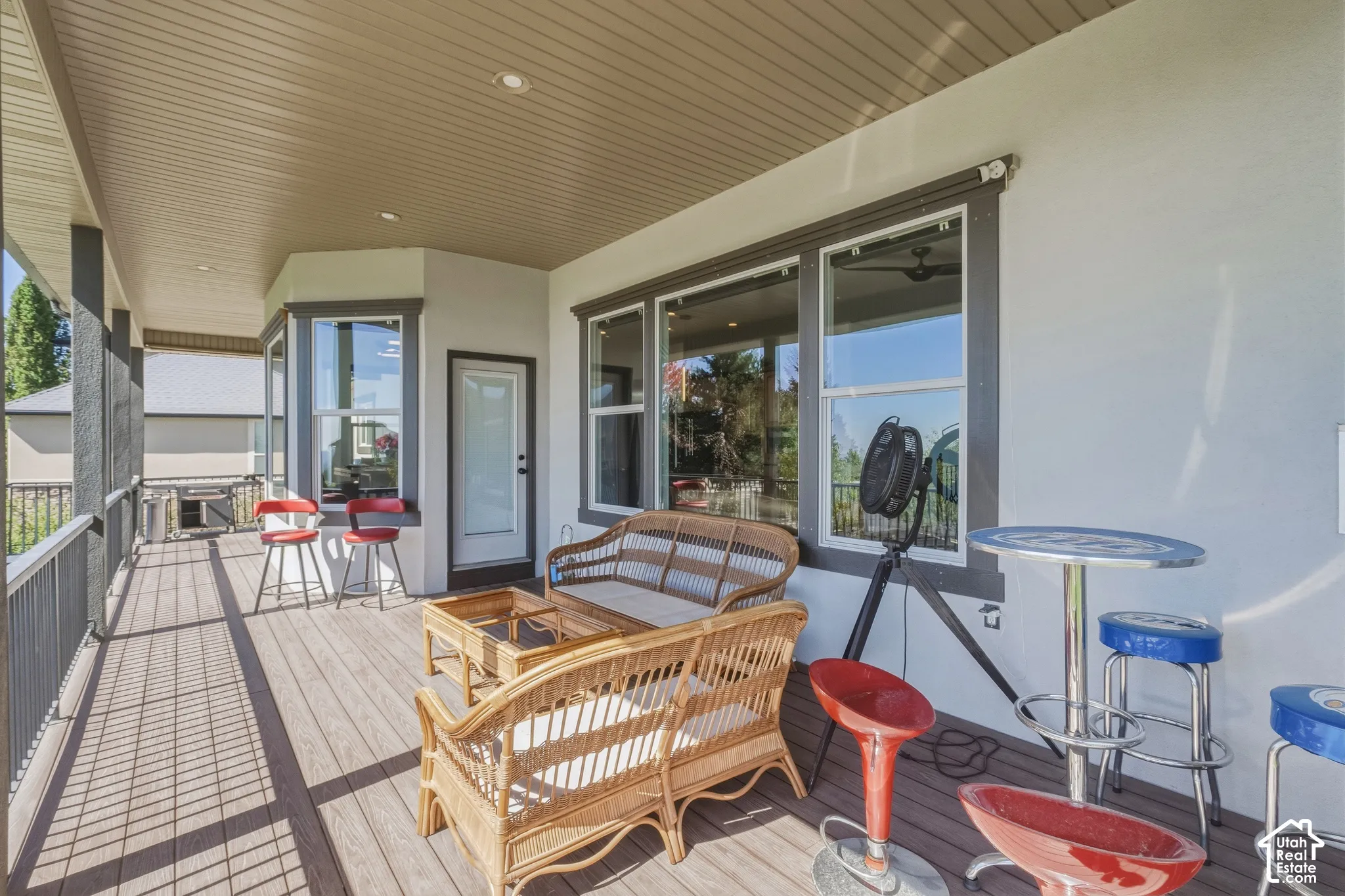 Expansive outdoor deck with composite flooring, recessed ceiling lighting, and a dark metal railing system