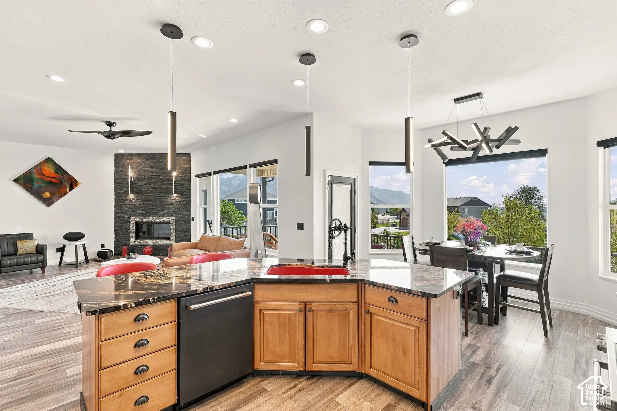 Open-concept kitchen featuring an island with stone countertops, wood-finish flooring, and recessed lighting