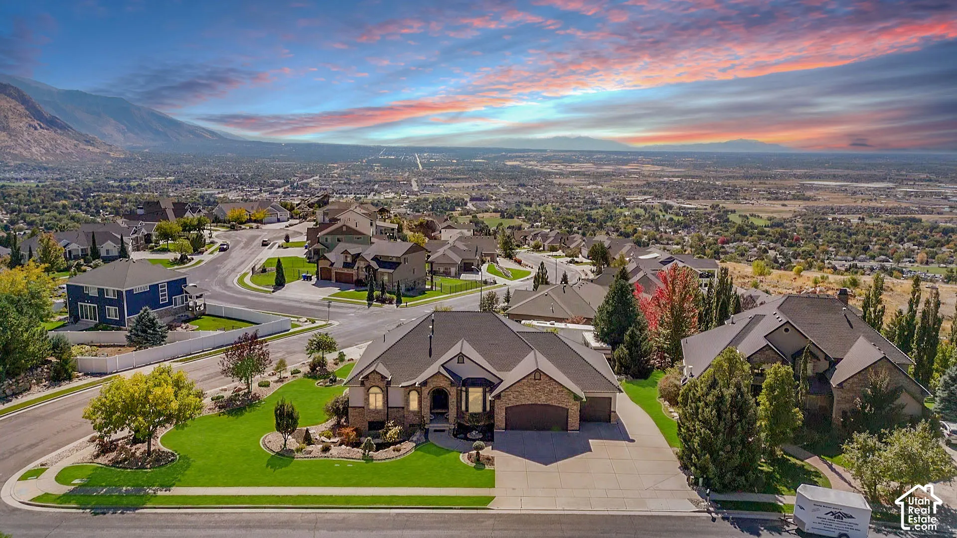 Spacious property featuring a large landscaped yard, stone exterior accents, an attached multi-car garage, and a concrete driveway