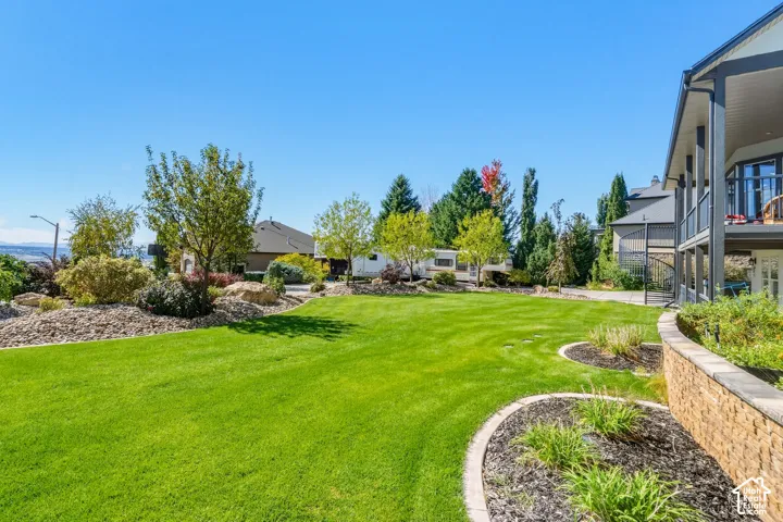 Expansive lawn area with a stone retaining wall and landscape edging