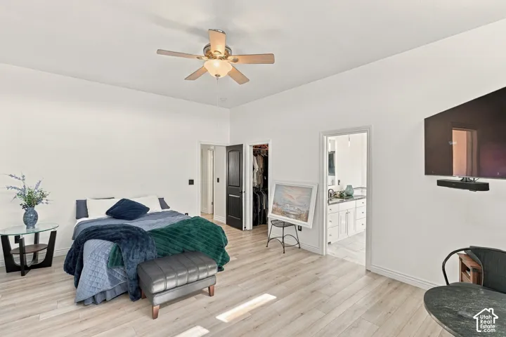 Wood-finish flooring throughout, ceiling fan with integrated lighting, and a wall-mounted television
