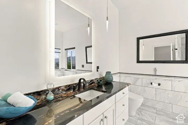 Built-in vanity with an undermount sink, dark granite countertop, and matte black faucet