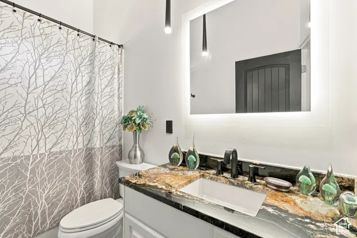 Spa-inspired bathroom featuring a floating vanity with a natural stone countertop, rectangular vessel sink, and matte black fixtures