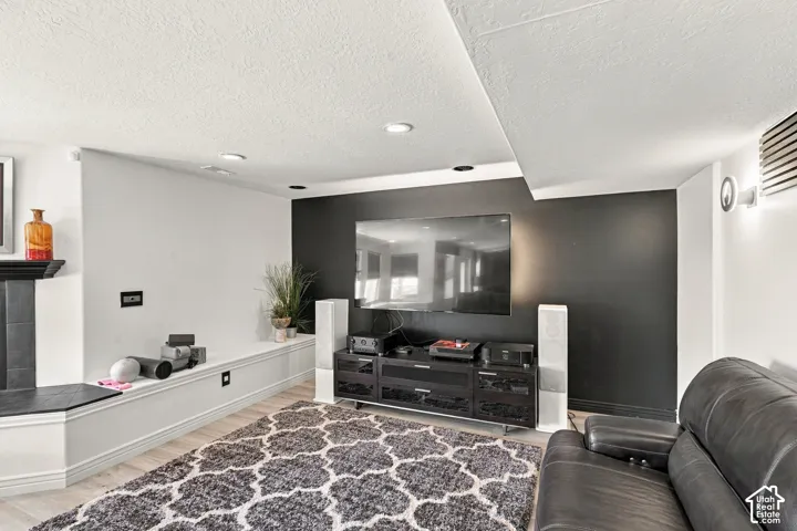 Light wood-finish flooring, recessed ceiling lighting, a built-in bench, and a dark accent wall