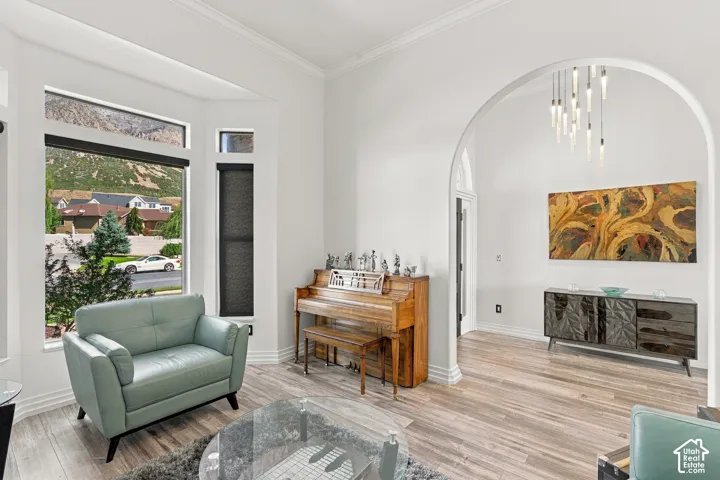 Bright living area featuring wood-finish flooring, a prominent arched doorway, and ample natural light through multiple windows
