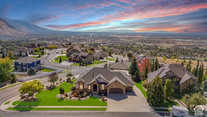 Spacious property featuring a large landscaped yard, stone exterior accents, an attached multi-car garage, and a concrete driveway