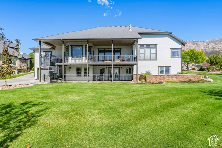 Modern two-story residence featuring a covered front porch with metal railings, expansive multi-pane windows, and a clean-lined architectural design