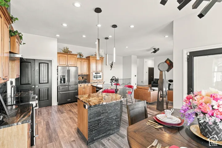 Kitchen featuring wood cabinetry, stainless steel appliances, and wood-finish flooring