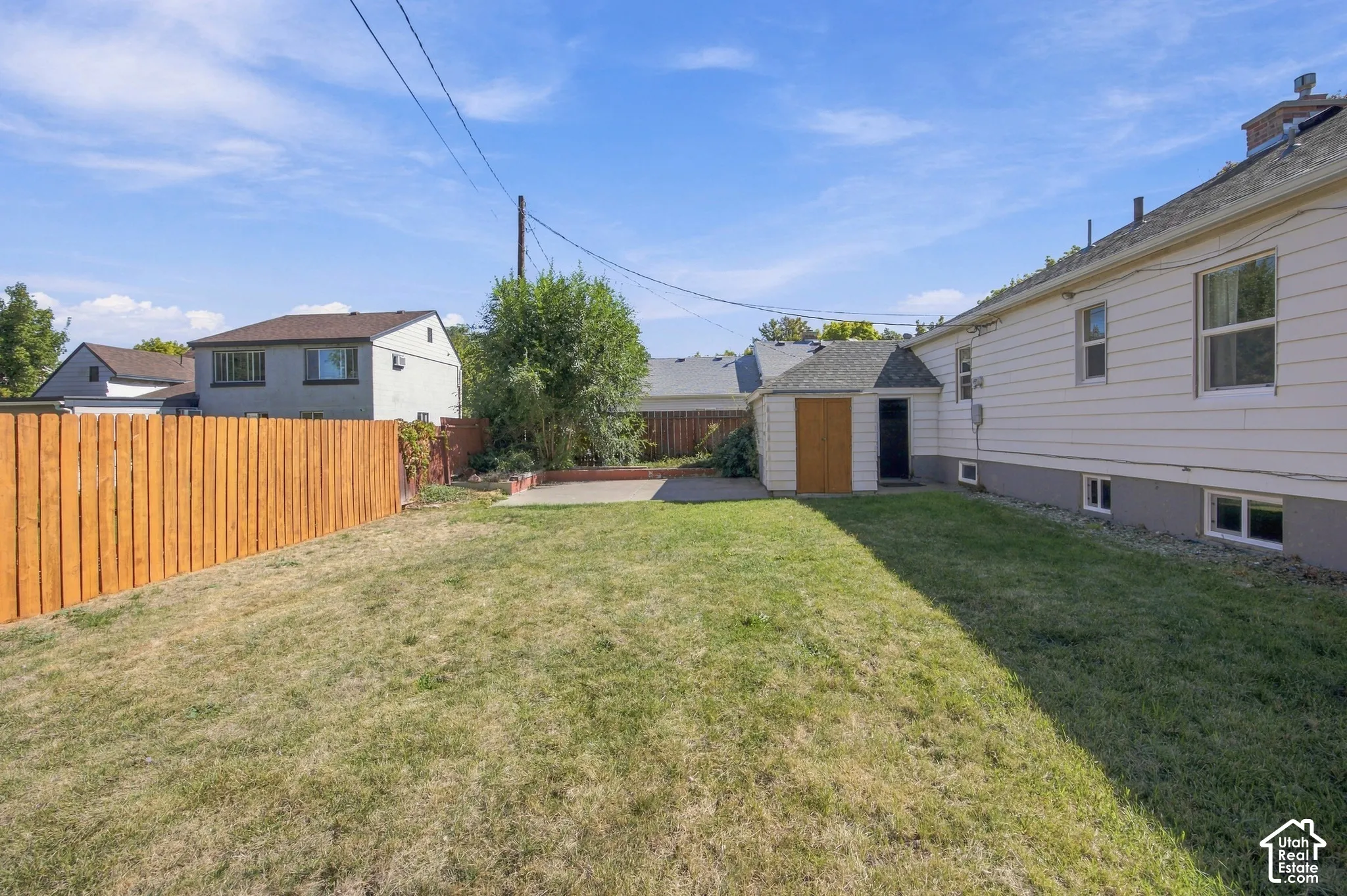 Expansive grassy yard area with a wood privacy fence