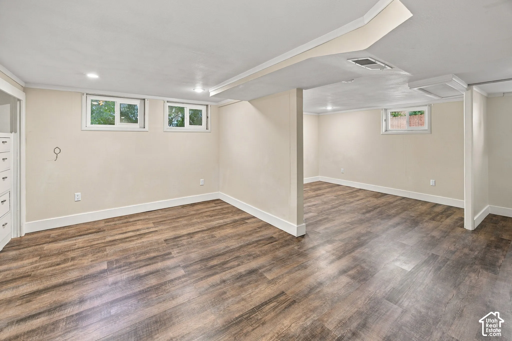 Recessed lighting, wood-finish flooring, white trim, and built-in cabinetry