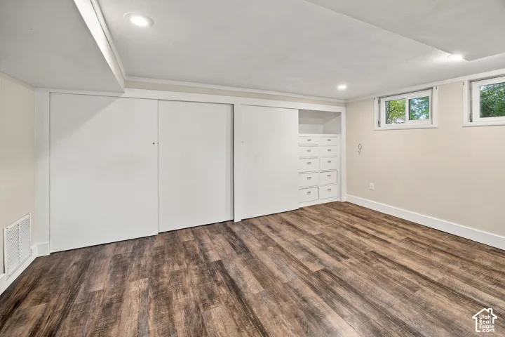 Wood-finish flooring with white trim and recessed lighting