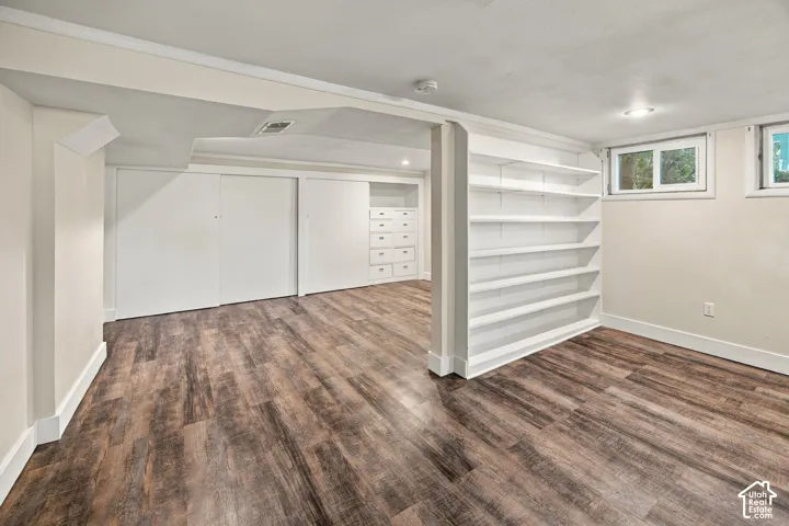 Wood-finish flooring, built-in shelving, recessed lighting, and sliding closet doors