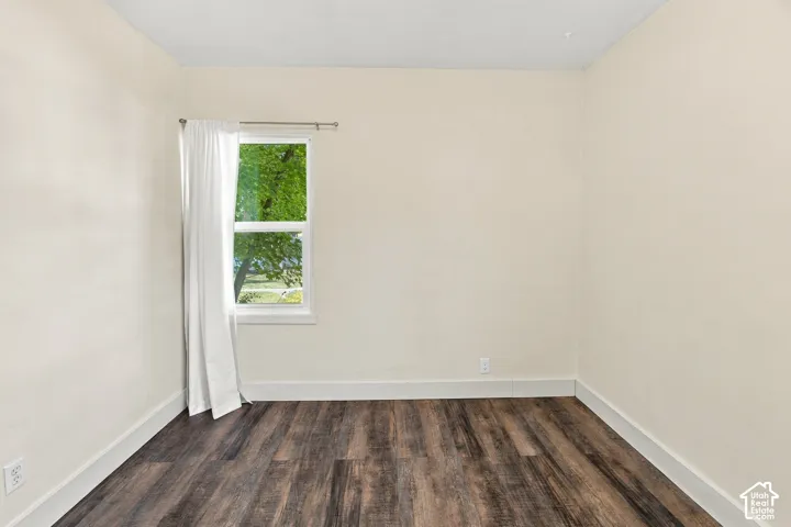 Wood-finish flooring, neutral wall tones, and a white-framed window