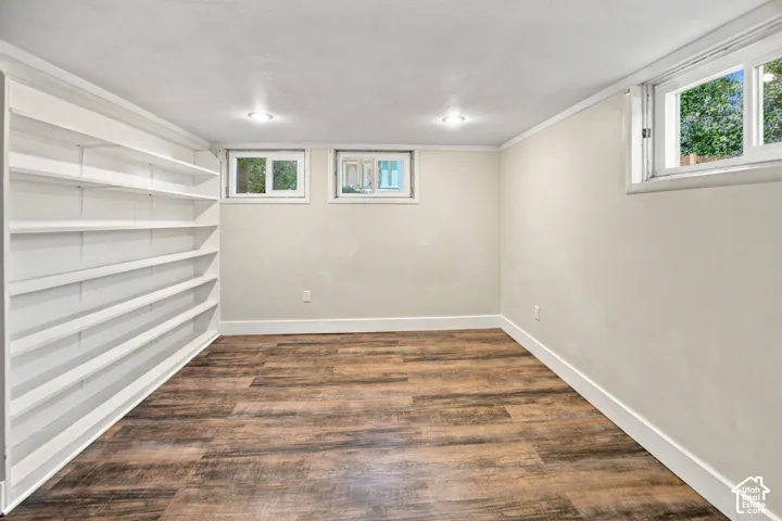 Built-in shelving, wood-finish flooring, recessed lighting, multiple windows, and white trim