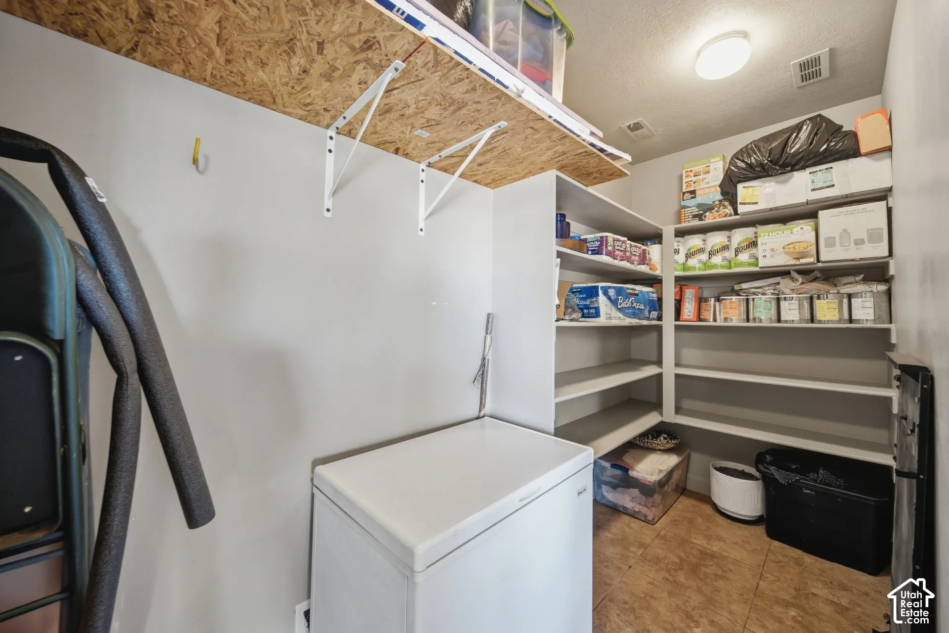 Built-in shelving for storage, wood-finish flooring, overhead lighting, and a neutral wall color