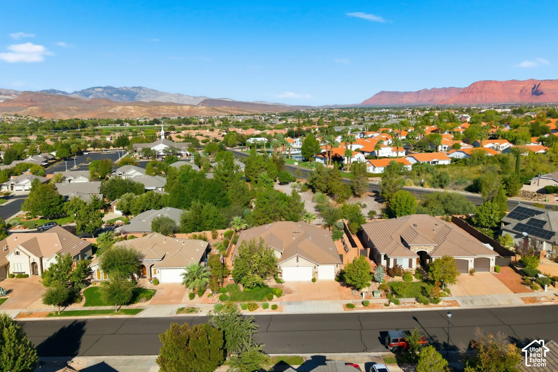 Residential neighborhood with mature trees, surrounded by distant mountains