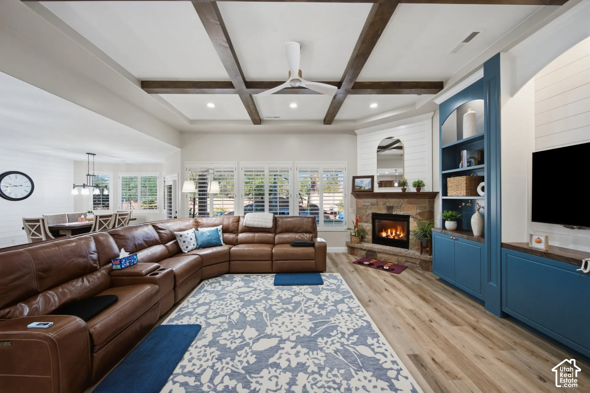 Tray ceiling with wood-finish beams, recessed lighting, and a ceiling fan