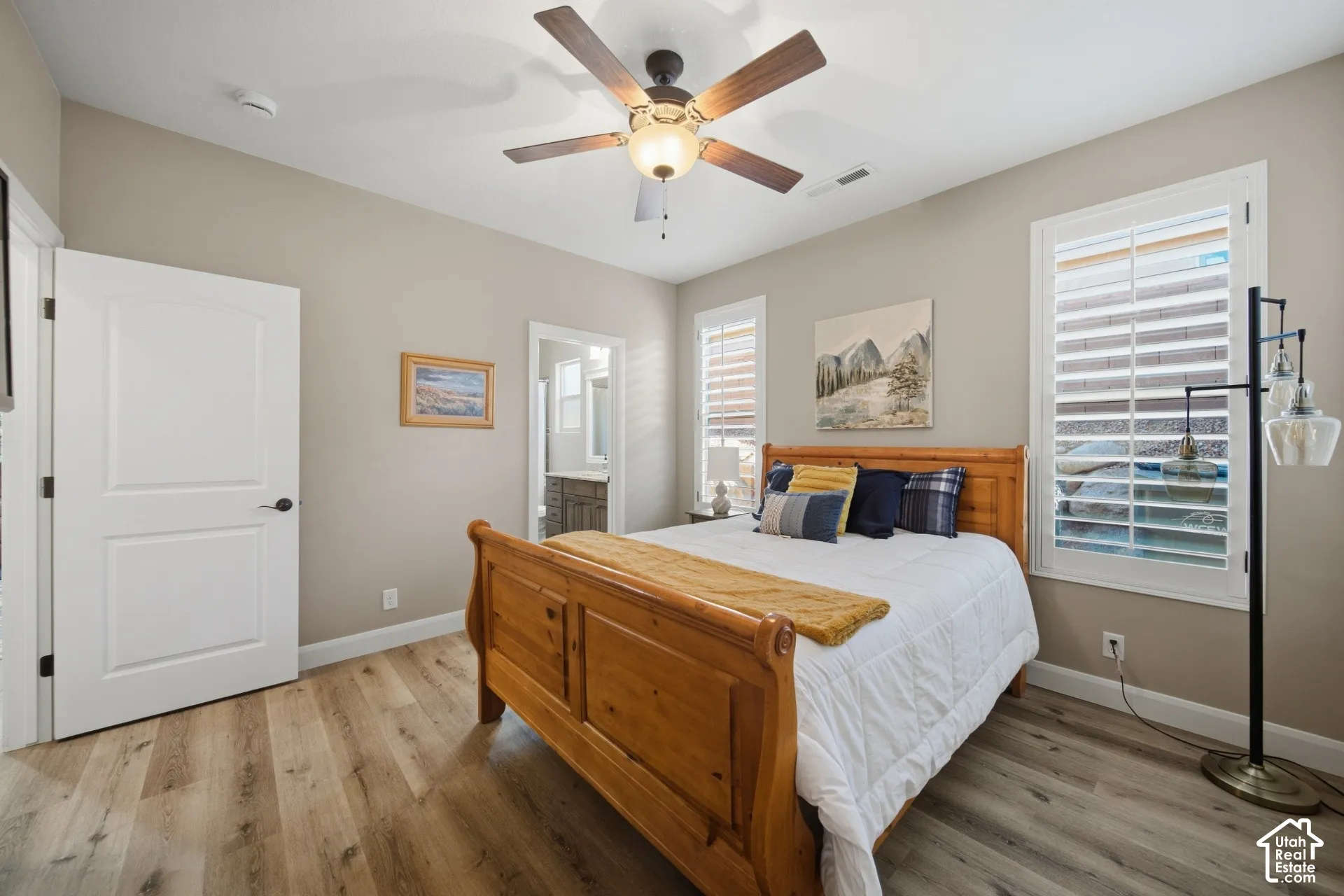 Wood-finish flooring throughout, ceiling fan with integrated lighting, and plantation shutters on multiple windows