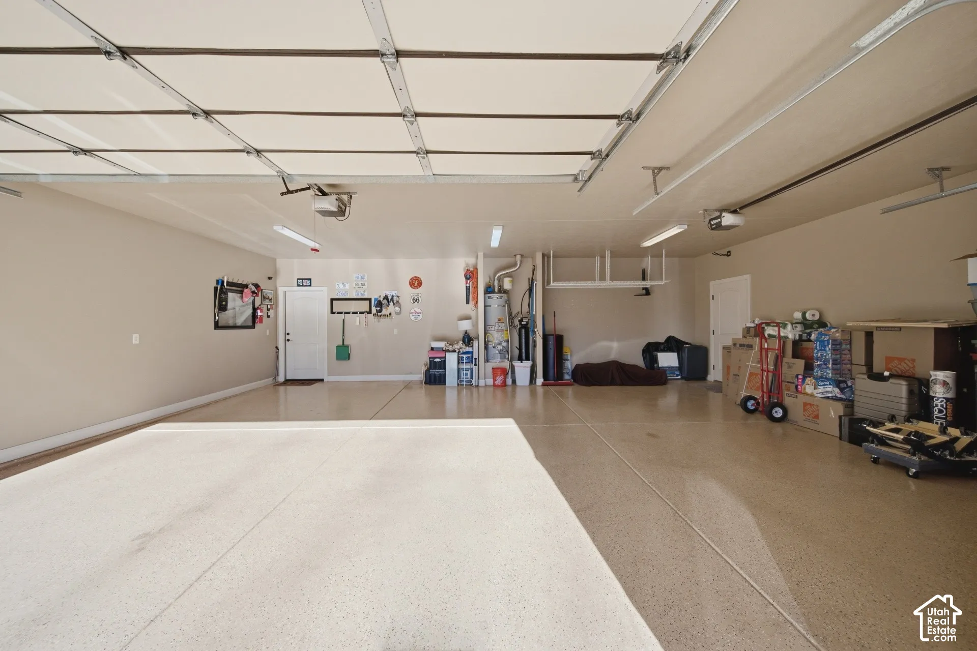 Spacious garage featuring a durable epoxy floor, overhead lighting, and an automatic garage door opener