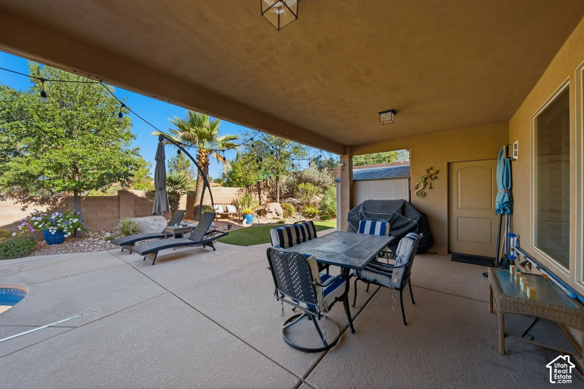 Covered patio featuring concrete flooring, an exterior door, and recessed lighting