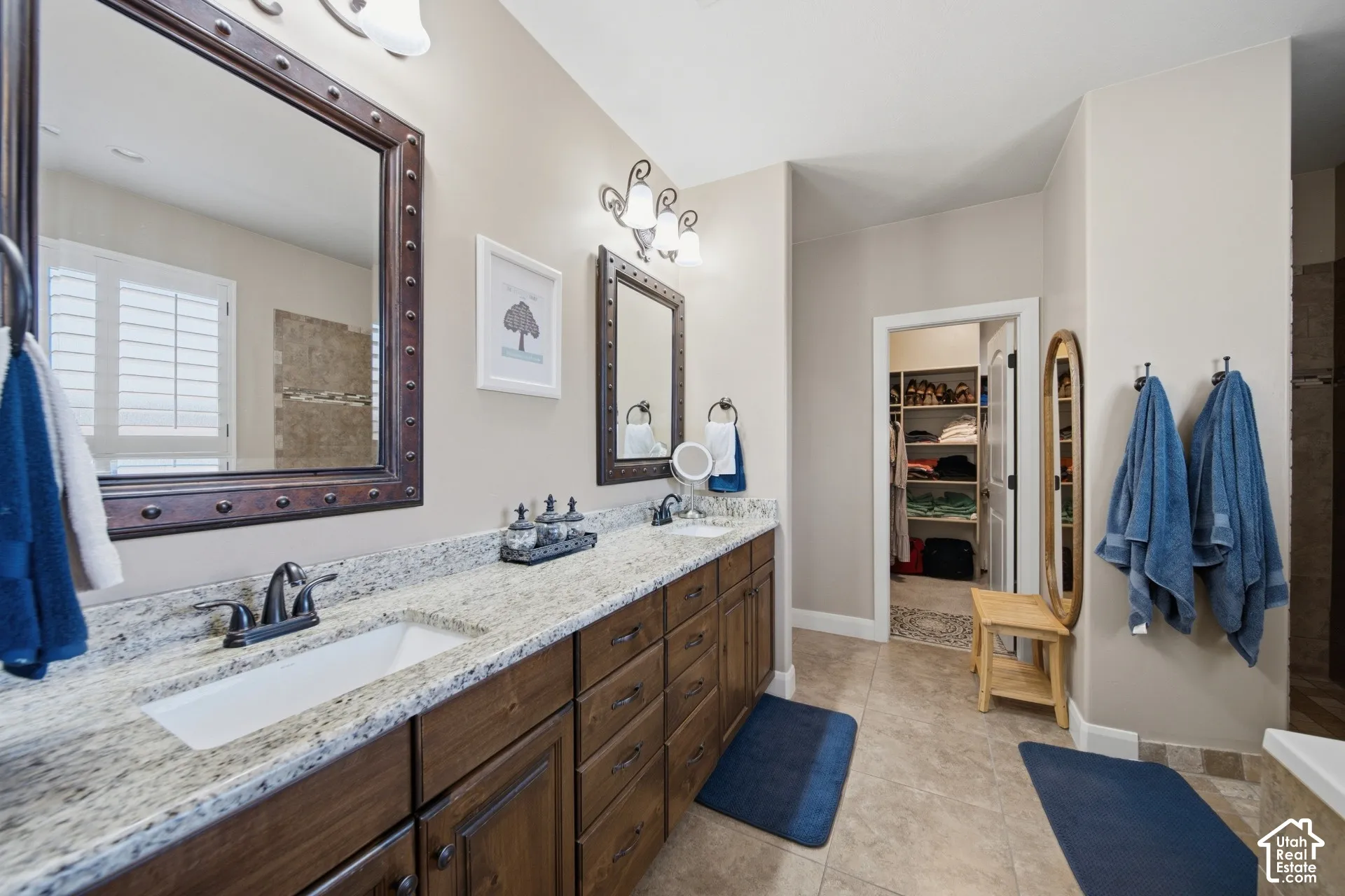 Double vanity with granite countertops, rich wood cabinetry, and dual undermount sinks