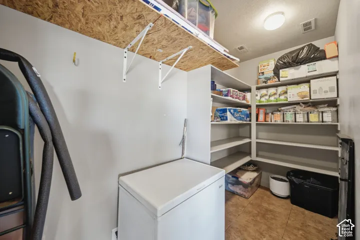 Built-in shelving for storage, wood-finish flooring, overhead lighting, and a neutral wall color