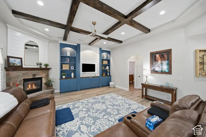 Wood-finish flooring with a stone-clad fireplace and wood beam ceiling